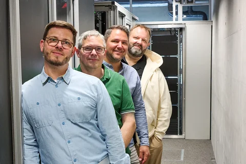Das Team der iWelt steht hintereinander im Serverraum