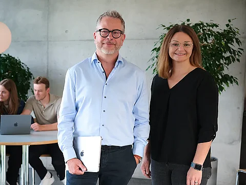 Zwei Führungskräfte der krick.com lächern in die Kamera